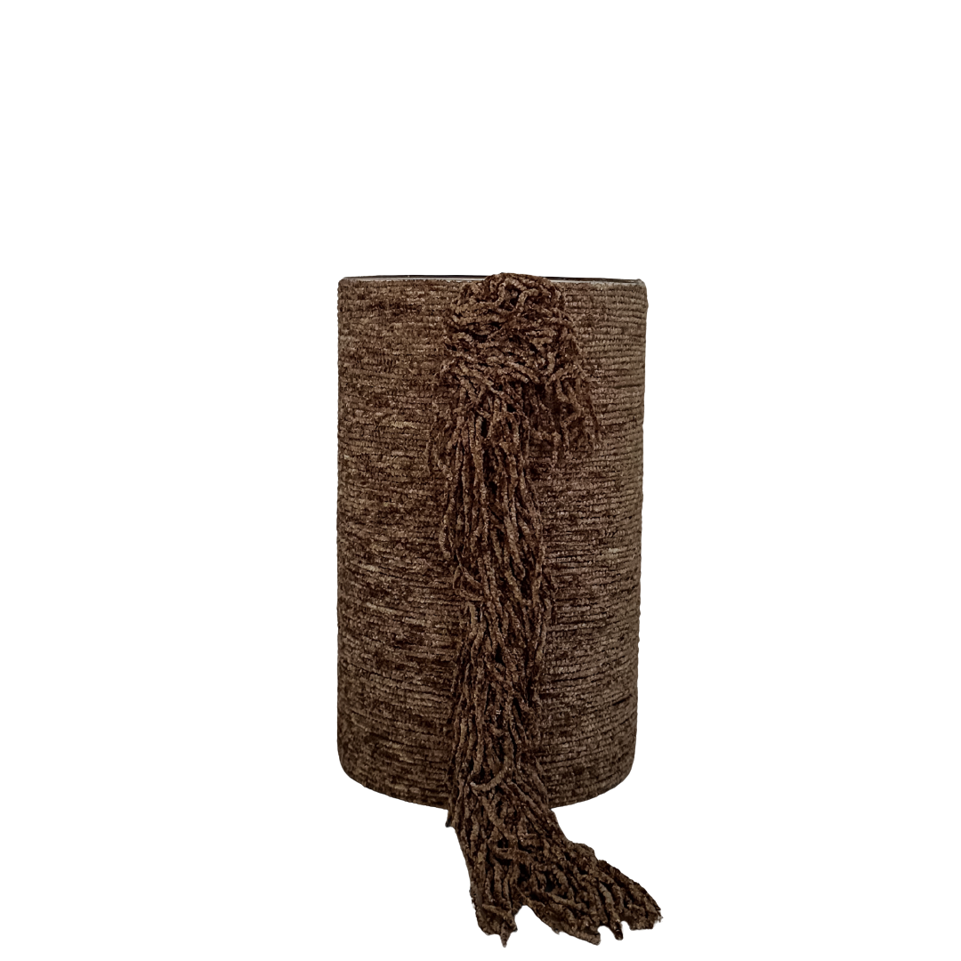 Cilindervormige kaarsenhouder met bruine stoffen bekleding en decoratieve franjes aan de voorzijde, op transparante achtergrond.