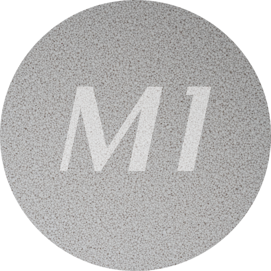 Kleurstaal van licht grijs kaarsenzand met fijne waxparels en subtiel M1-logo op de achtergrond.