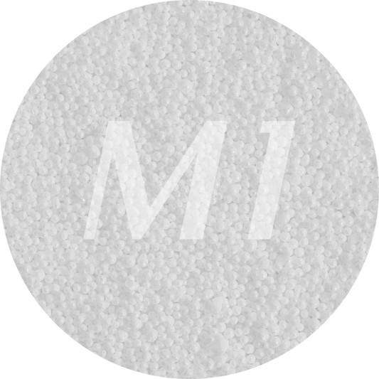 Kleurstaal van wit kaarsenzand met fijne waxparels en subtiel M1-logo op de achtergrond.
