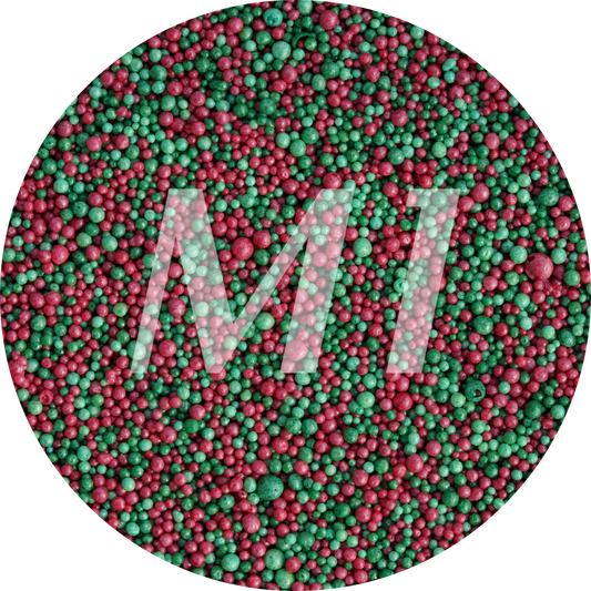 Kleurstaal van groen en rood kaarsenzand met fijne waxparels en subtiel M1-logo op de achtergrond.