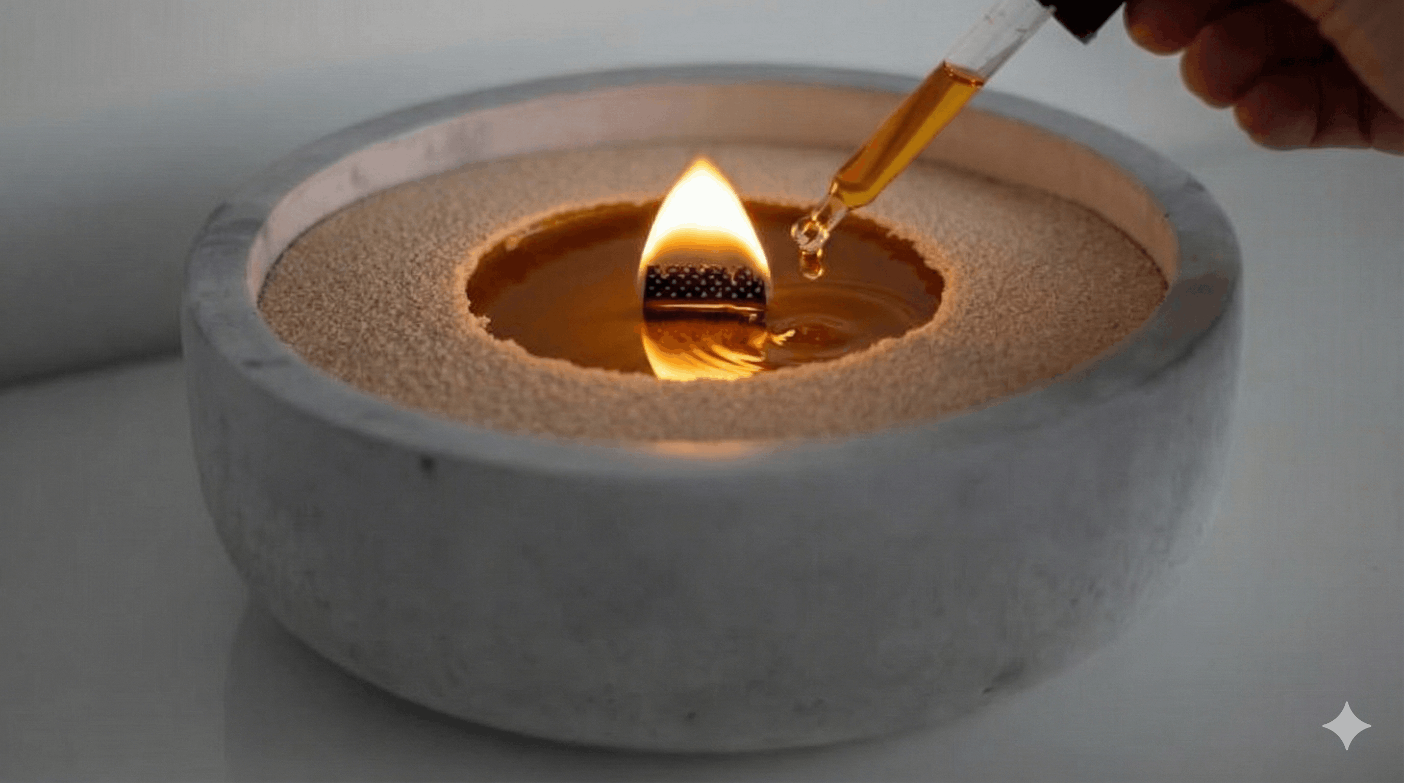 Close-up van kaarsenzand met lont in een decoratieve houder terwijl geurolie wordt toegevoegd voor een intensere geur en sfeervolle vlam.