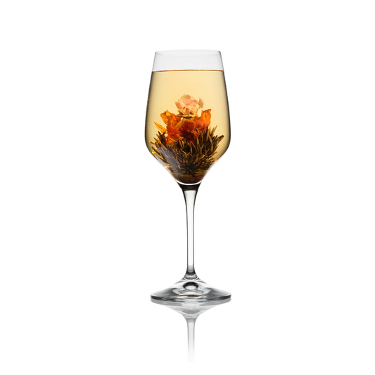 Bloeiende theebloem Hearts Desire met roos en lelie in Flora Tea wijnglas