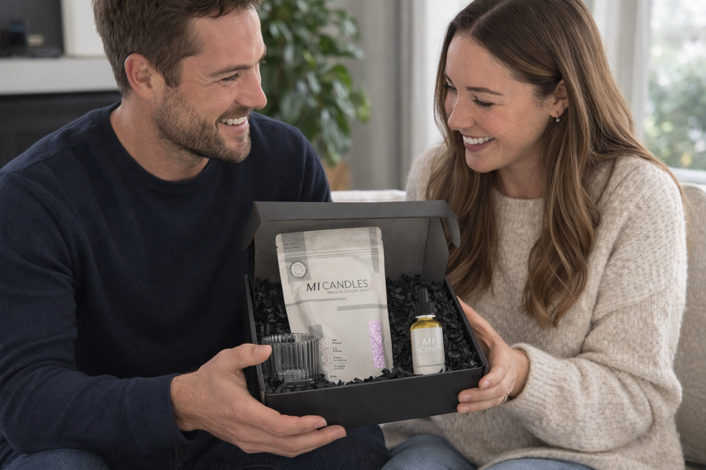 Man en vrouw openen een luxe M1 Candles giftbox met kaarsenzand, glazen kaarshouder en geurolie als origineel en stijlvol cadeau.