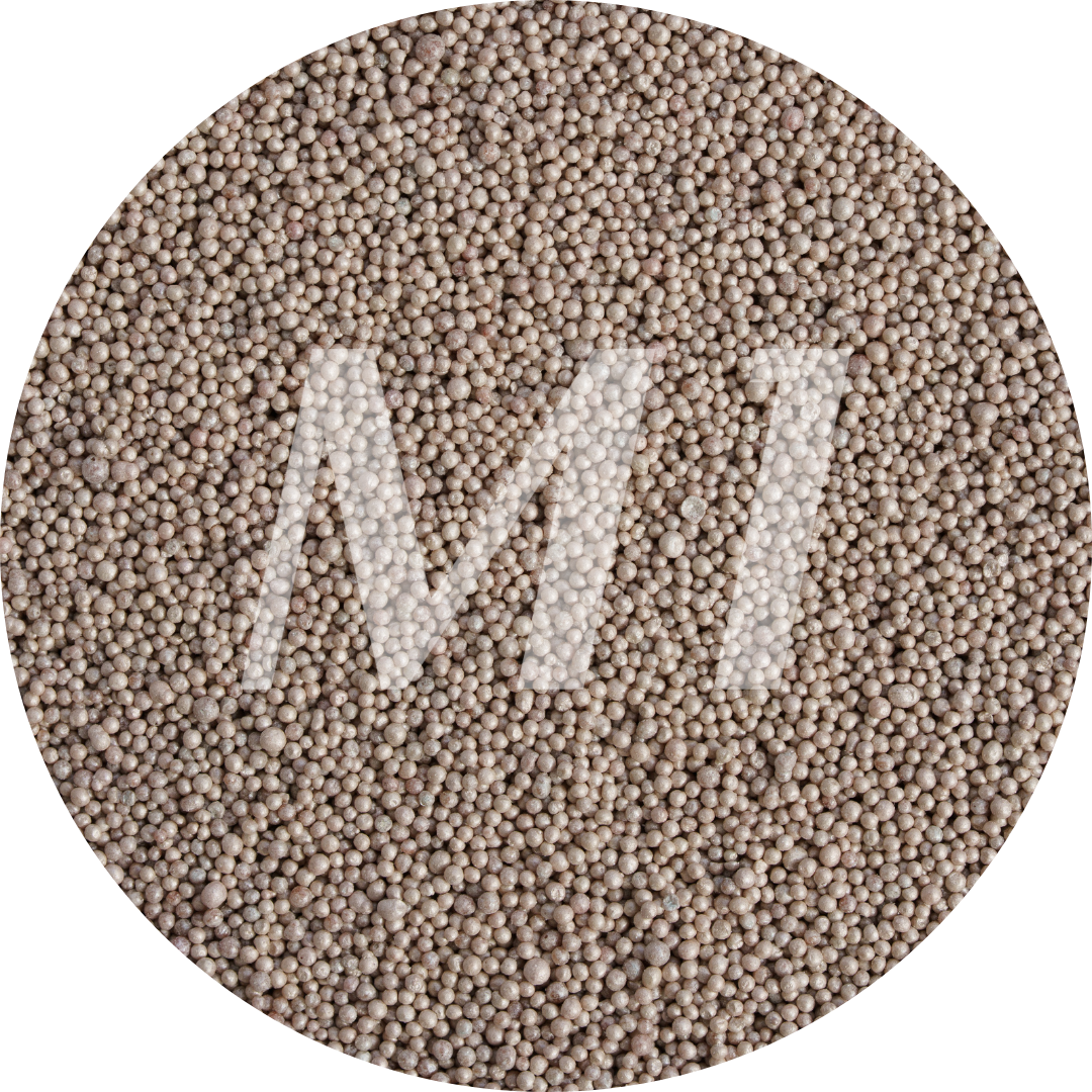 Kleurstaal van bruin kaarsenzand met fijne waxparels en subtiel M1-logo op de achtergrond.