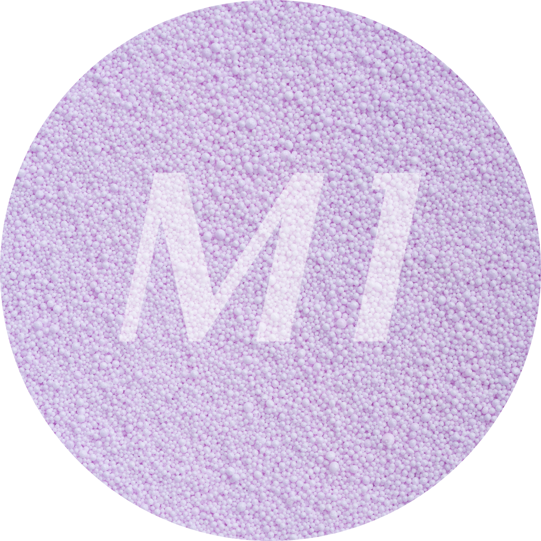 Kleurstaal van lilac kaarsenzand met fijne waxparels en subtiel M1-logo op de achtergrond.