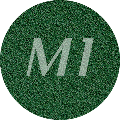 Kleurstaal van donker groen kaarsenzand met fijne waxparels en subtiel M1-logo op de achtergrond.