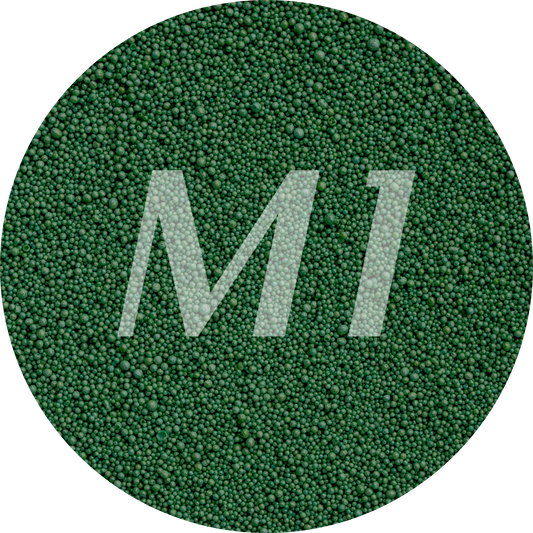 Kleurstaal van donker groen kaarsenzand met fijne waxparels en subtiel M1-logo op de achtergrond.