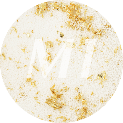 Kleurstaal van wit kaarsenzand met gouden glinsterflakes en subtiel M1-logo op de achtergrond.