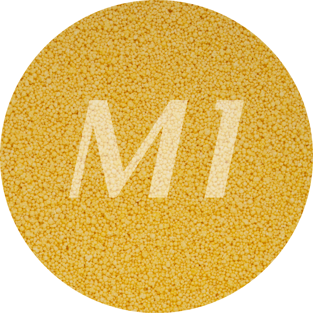 Kleurstaal van geel kaarsenzand met fijne waxparels en subtiel M1-logo op de achtergrond.