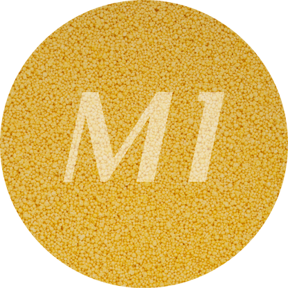 Kleurstaal van geel kaarsenzand met fijne waxparels en subtiel M1-logo op de achtergrond.