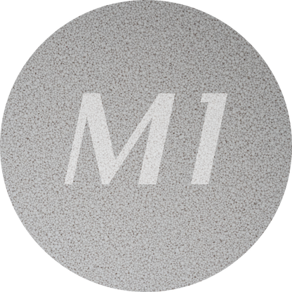 Kleurstaal van licht grijs kaarsenzand met fijne waxparels en subtiel M1-logo op de achtergrond.