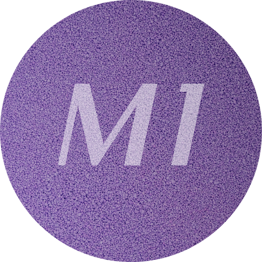 Kleurstaal van paars kaarsenzand met fijne waxparels en subtiel M1-logo op de achtergrond.
