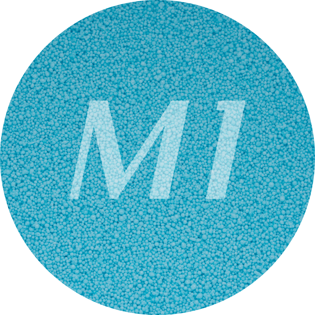 Kleurstaal van fel blauw kaarsenzand met fijne waxparels en subtiel M1-logo op de achtergrond.