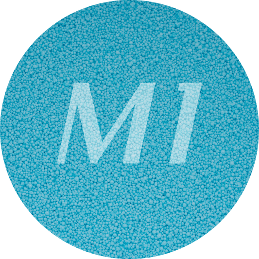 Kleurstaal van fel blauw kaarsenzand met fijne waxparels en subtiel M1-logo op de achtergrond.