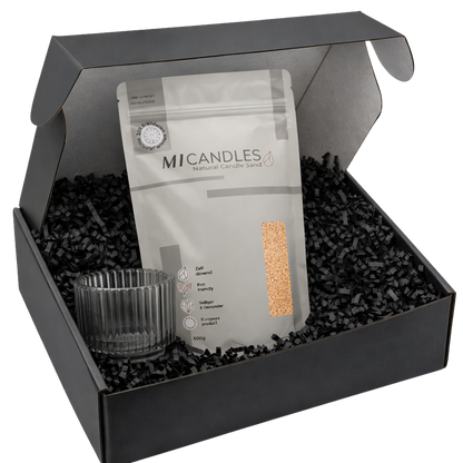 Zwarte luxe giftbox met M1 Candles candle sand in hersluitbare verpakking, glazen kaarshouder en zwarte papieren opvulsnippers, stijlvol gepresenteerd als complete cadeauset.