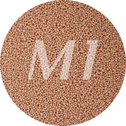 Kleurstaal van terra cotta kaarsenzand met fijne waxparels en subtiel M1-logo op de achtergrond.