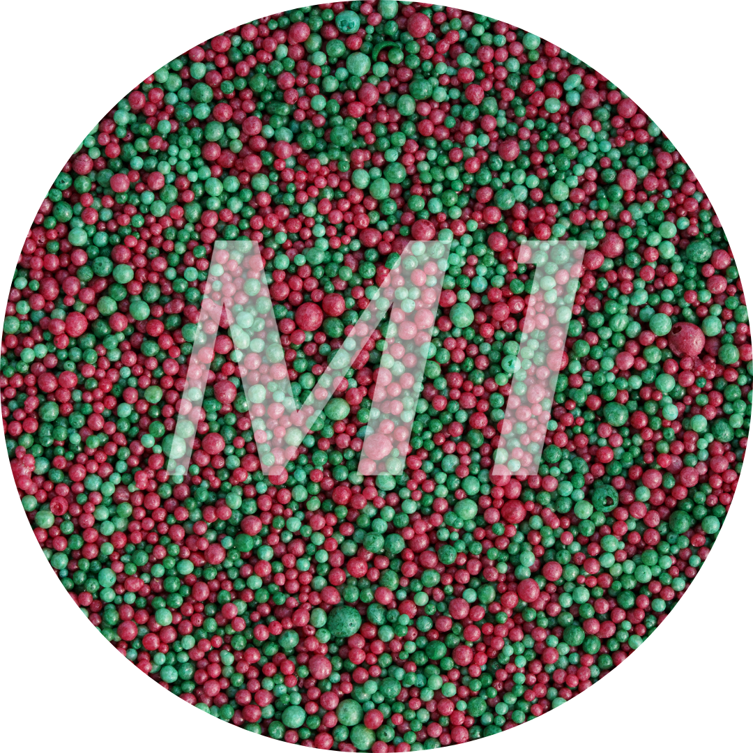 Kleurstaal van groen en rood kaarsenzand met fijne waxparels en subtiel M1-logo op de achtergrond.