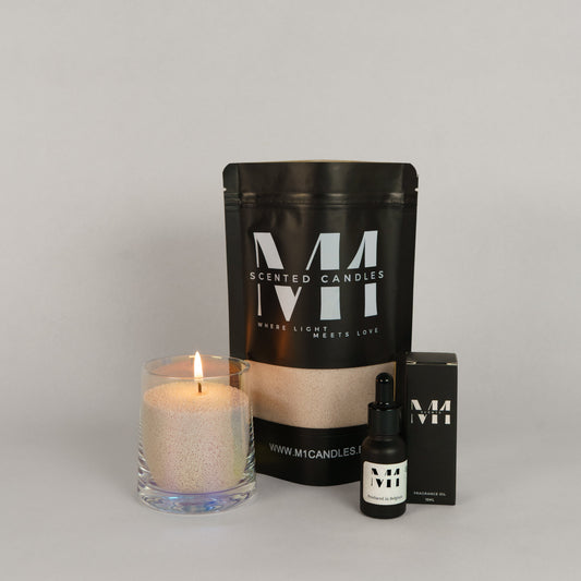 Set van M1 Scented Candles bestaande uit een brandend glas met kaarsenzand, een zwarte zak met kaarsenzand en een flesje geurolie met verpakking.