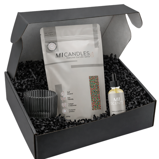 Zwarte giftbox met M1 Candles candle sand in hersluitbare verpakking, M1 Scents Vanilla Patchouli geurolie en zwart opvulmateriaal, stijlvol gepresenteerd als luxe cadeauset.
