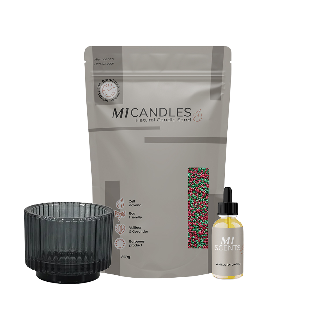 M1 Candles Natural Candle Sand (250g) in rood-groen mix, met zwarte glazen houder en M1 Scents geurolie Vanilla Patchouli.