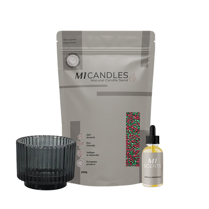 M1 Candles Natural Candle Sand (250g) in rood-groen mix, met zwarte glazen houder en M1 Scents geurolie Vanilla Patchouli.